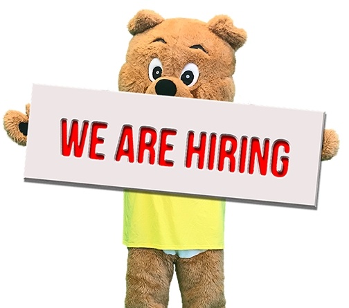 Person in bear suit holding sign saying we are hiring