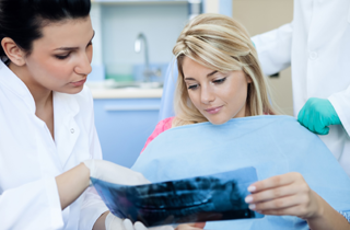 Dental patient and office manager examining x-rays