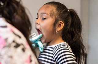 child brushing teeth near team member