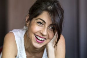 A woman wearing braces and smiling.