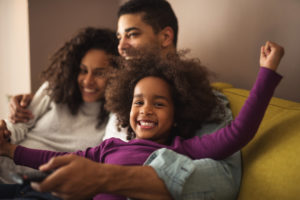 family of four hugging and laughing