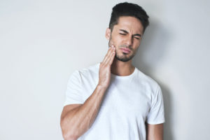 a man experiencing pain from a wisdom tooth