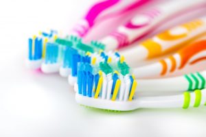 A series of multi-colored toothbrushes.