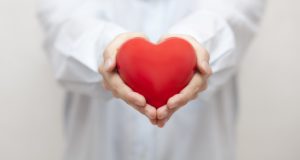dentist in Pleasant Grove holding a heart model