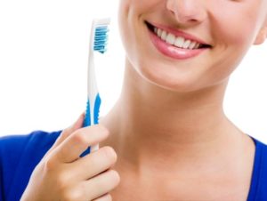 woman holding a toothbrush after visiting dentist in Mesquite