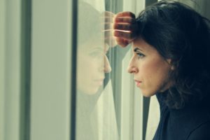 A woman looking outside a window.