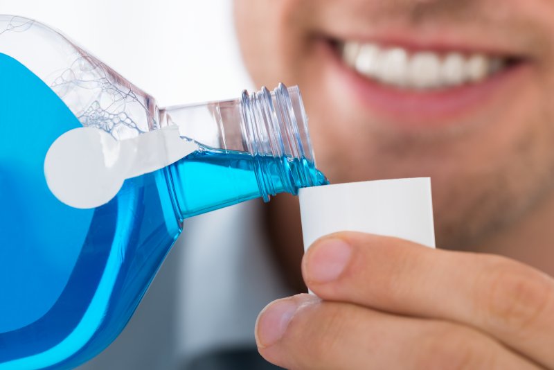 Man pouring mouthwash into small cup