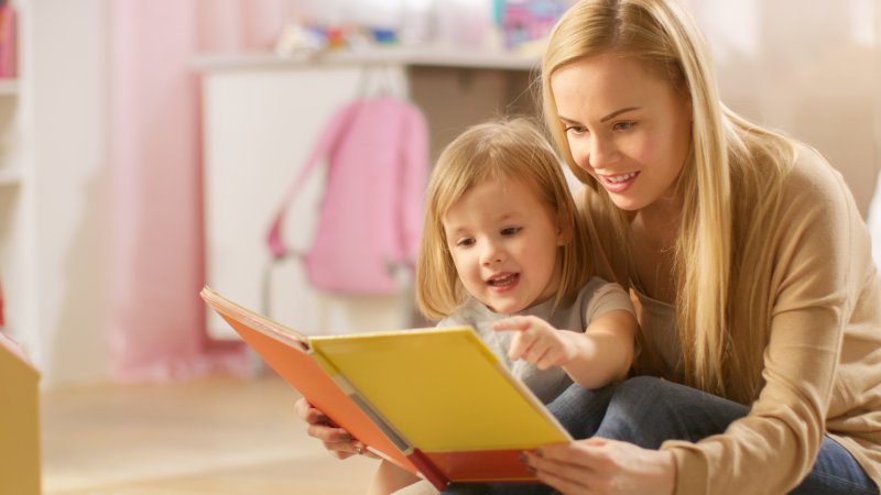 Mother and child reading book together