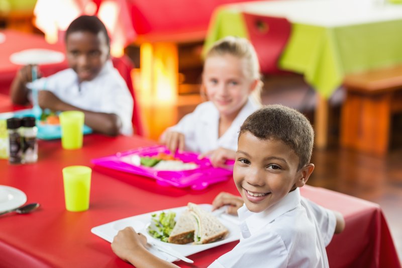 child smiling during school lunch