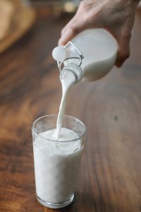 Hand pouring milk in glass