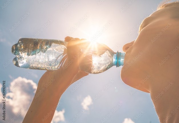 Woman drinking water on hot summer day