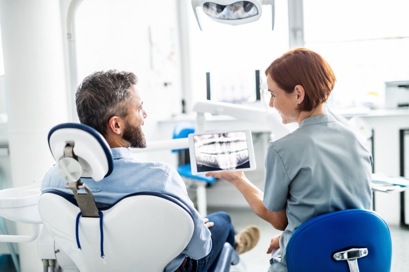 A dentist in Far North Dallas working with a patient