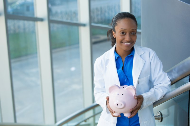 A dentist in Duncanville holding a piggy bank