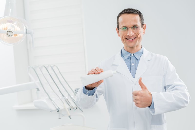 A dentist in North Dallas holding toothpaste