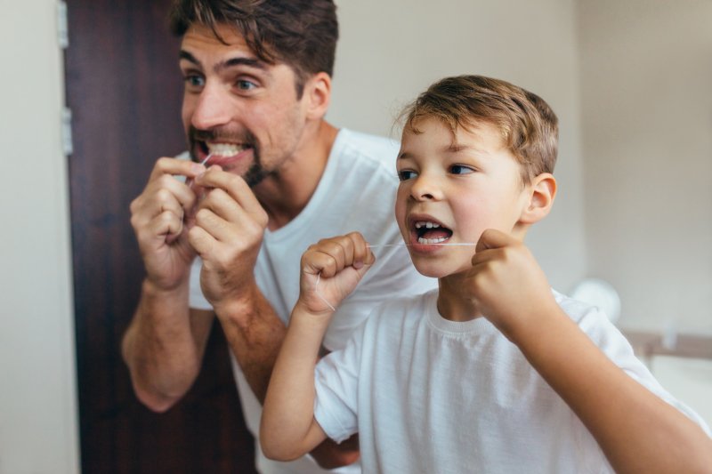 a man and his son flossing