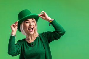 a woman smiling and celebrating St. Patrick’s Day