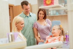 Patents beside young girl speaking with a dentist