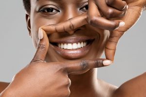 Woman framing her smile with her fingers