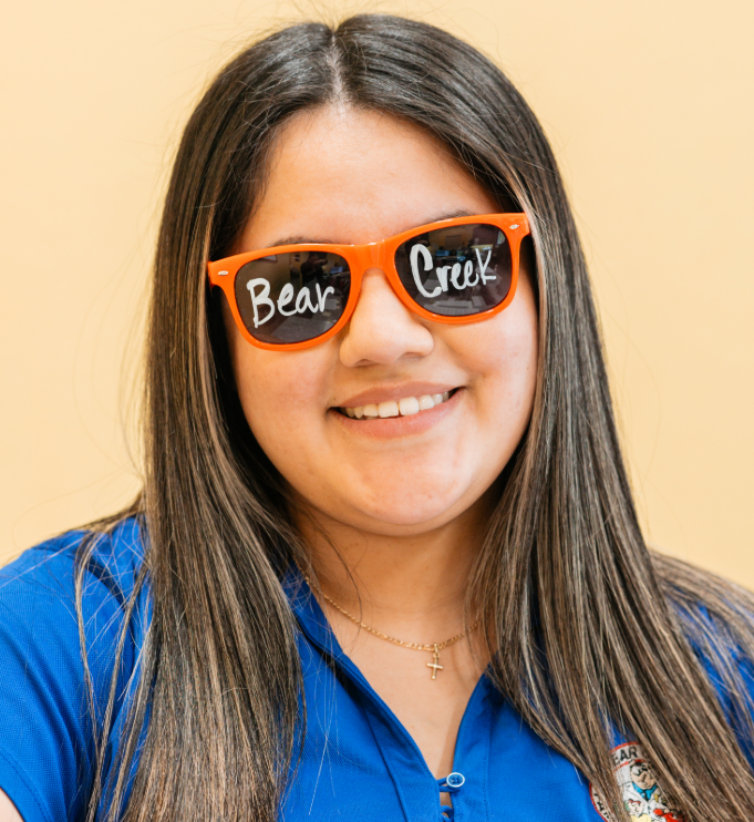 Smiling woman wearing sunglasses with Bear Creek written on them