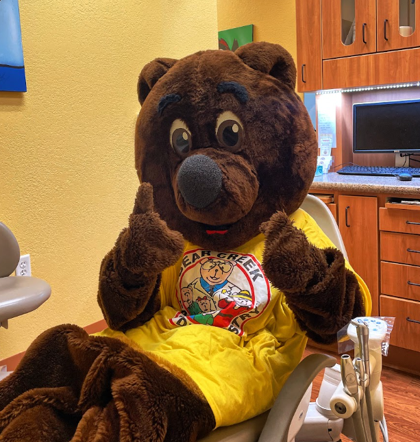 Bear mascot sitting in dental chair