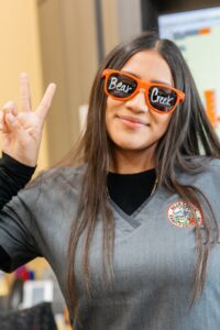 Dental office staff member wearing sunglasses and giving peace sign.